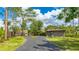 Charming home exterior featuring a winding driveway, mature trees, and a two-car garage for ample parking space at 5135 Riverwood Ave, Sarasota, FL 34231
