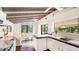 Kitchen interior showcasing white cabinets, wooden floors, ceiling fans, and natural light from the windows at 5135 Riverwood Ave, Sarasota, FL 34231
