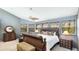 This is the main bedroom with a ceiling fan, carpet floors, and multiple windows with wooded views at 5135 Riverwood Ave, Sarasota, FL 34231