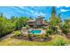 Backyard view of a beautiful home featuring a private pool, spacious deck, and lush landscaping for outdoor relaxation at 5135 Riverwood Ave, Sarasota, FL 34231