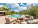 A backyard patio with an in-ground pool and outdoor seating under a sunny blue sky at 5135 Riverwood Ave, Sarasota, FL 34231