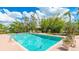 Backyard pool featuring patio, green foliage, and bright blue sky at 5135 Riverwood Ave, Sarasota, FL 34231