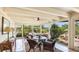 The porch features a cozy seating arrangement, neutral rug, and ceiling fan to offer a relaxing atmosphere at 5135 Riverwood Ave, Sarasota, FL 34231