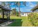 A beautiful backyard features green grass, mature trees, and a screened in lanai at 6124 Green View Dr # 139, Sarasota, FL 34231