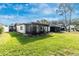 A full view of the back of the home shows the lush green grass and large screened-in lanai at 6124 Green View Dr # 139, Sarasota, FL 34231