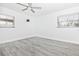 Bedroom featuring gray wood floors, a ceiling fan, and two windows at 6124 Green View Dr # 139, Sarasota, FL 34231