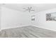 Bright bedroom featuring light gray wood floors, a ceiling fan, and two windows at 6124 Green View Dr # 139, Sarasota, FL 34231