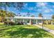A clear blue sky behind the clubhouse with a well-maintained lawn and professional landscaping at 6124 Green View Dr # 139, Sarasota, FL 34231
