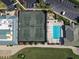 Aerial view highlighting tennis courts and a pool within the community, surrounded by trees at 6501 Stone River Rd # 205, Bradenton, FL 34203