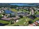 Expansive aerial view of the community with golf course, lake, swimming pool, tennis court, and clubhouse at 6501 Stone River Rd # 205, Bradenton, FL 34203