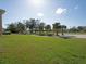 Wide backyard with a luscious green lawn and trees in the background at 6501 Stone River Rd # 205, Bradenton, FL 34203