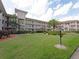 Well-maintained building exterior with balconies overlooking a green lawn and landscaping at 6501 Stone River Rd # 205, Bradenton, FL 34203