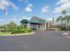Attractive clubhouse featuring a covered entrance, lush landscaping, and a well-maintained exterior at 6501 Stone River Rd # 205, Bradenton, FL 34203