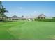 Exterior view of the clubhouse with a manicured lawn and putting green in the foreground at 6501 Stone River Rd # 205, Bradenton, FL 34203
