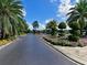 Scenic entrance with manicured landscaping, flowers, and palm trees along the driveway at 6501 Stone River Rd # 205, Bradenton, FL 34203