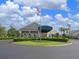 A well-manicured circular entrance with decorative landscaping and an American flag waving in the breeze at 6501 Stone River Rd # 205, Bradenton, FL 34203