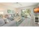 Open-concept living room with sliding glass doors to sunroom, offering natural light at 6501 Stone River Rd # 205, Bradenton, FL 34203