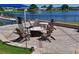 Outdoor seating area with brick patio, fire pit, and comfortable Adirondack chairs overlooking a serene lake at 6501 Stone River Rd # 205, Bradenton, FL 34203