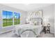 Light-filled bedroom with large window, white bedding, side tables, lamps, and stylish decor at 128 Sequoyah Dr, Port Charlotte, FL 33954