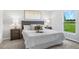 Comfortable bedroom with tufted headboard, plush bedding, bedside tables, lamps and a view of the outside at 128 Sequoyah Dr, Port Charlotte, FL 33954