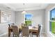 Elegant dining area with modern lighting, neutral colors and backyard views for serene dining experiences at 128 Sequoyah Dr, Port Charlotte, FL 33954