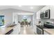 Contemporary kitchen with stainless steel appliances, open to a dining area with verdant backyard views at 128 Sequoyah Dr, Port Charlotte, FL 33954
