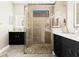 Modern bathroom with a glass-enclosed shower, stone floors and double vanity sinks at 13038 Prima Dr, Bradenton, FL 34211
