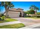 Beautiful single-story home featuring a paver driveway, terra cotta roof, and lush tropical landscaping at 13038 Prima Dr, Bradenton, FL 34211