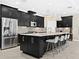 Modern kitchen features stainless steel appliances, a large island with seating, and sleek, dark cabinetry at 13038 Prima Dr, Bradenton, FL 34211