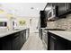 Stylish kitchen features a large island, stainless steel appliances, and sleek, dark cabinetry and countertops at 13038 Prima Dr, Bradenton, FL 34211