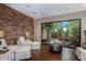 Relax in this room with a stone accent wall and a picturesque garden view from the large window at 13038 Prima Dr, Bradenton, FL 34211