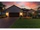 Charming single-story home with well-manicured lawn and elegant landscaping at sunset at 15209 Montello Way, Bradenton, FL 34211