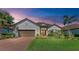 Charming single-story home featuring a well-manicured lawn, mature landscaping, and a brick driveway at 15209 Montello Way, Bradenton, FL 34211