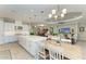 Open kitchen and dining area with white cabinets, a large island, and modern lighting at 15209 Montello Way, Bradenton, FL 34211