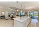 Open concept kitchen featuring a large island with white countertops, stainless steel appliances, and a seamless connection to the living area at 15209 Montello Way, Bradenton, FL 34211