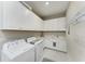 Functional laundry room with white cabinets and modern washer and dryer at 15209 Montello Way, Bradenton, FL 34211
