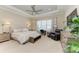 Serene main bedroom with tray ceilings, a comfortable seating area, and ample natural light at 15209 Montello Way, Bradenton, FL 34211