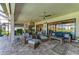 Large screened-in patio area featuring comfortable wicker furniture, ceiling fans, and an outdoor kitchen at 15209 Montello Way, Bradenton, FL 34211