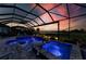 Twilight view of the screened-in pool and spa area overlooking a golf course at 15209 Montello Way, Bradenton, FL 34211