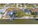 Aerial view of a home on a canal featuring a boat lift, screened-in pool and mature landscaping at 1950 Fairview Dr, Englewood, FL 34223