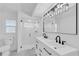 This modern bathroom offers a walk-in shower and a dual sink vanity with sleek black fixtures at 1950 Fairview Dr, Englewood, FL 34223