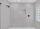 This modern shower features sleek gray tile, a frameless glass door, and an inset shelf for added convenience at 1950 Fairview Dr, Englewood, FL 34223