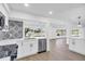 Modern kitchen features stainless appliances, white cabinets and granite countertops with a view to the living room and outside at 1950 Fairview Dr, Englewood, FL 34223