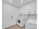 Well-organized laundry room with white cabinets and modern washer and dryer at 1950 Fairview Dr, Englewood, FL 34223