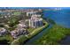 Aerial view of waterfront condos along a canal, lush landscaping, and a golf course in the distance at 2012 Harbourside Dr # 2104, Longboat Key, FL 34228