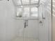 All-white bathroom with a glass shower and patterned accent tiles, perfect for a clean and serene experience at 2012 Harbourside Dr # 2104, Longboat Key, FL 34228