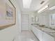 Well-lit bathroom with double sinks, granite countertops, and tile flooring at 2012 Harbourside Dr # 2104, Longboat Key, FL 34228