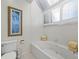 Bathroom with a jacuzzi tub, tiled walls, and shuttered windows at 2012 Harbourside Dr # 2104, Longboat Key, FL 34228