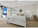 Bright bedroom features a king bed with a white comforter, adjacent to sliding glass doors and private outdoor spa at 2012 Harbourside Dr # 2104, Longboat Key, FL 34228