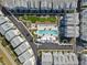 Overhead view of a community pool with lounge chairs, flanked by neatly arranged townhomes and manicured green spaces at 2505 Boone Ct, Sarasota, FL 34237